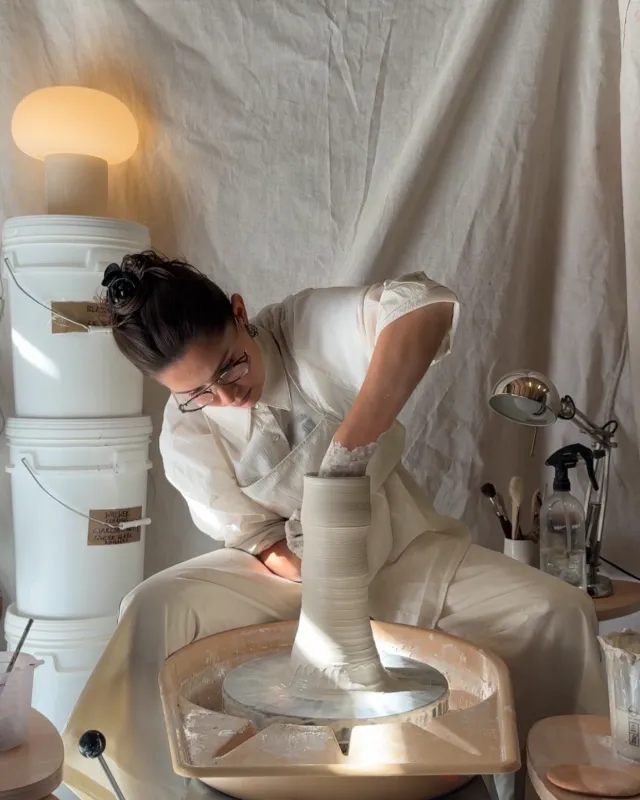 Annabel throwing a pot on a wheel in her studio