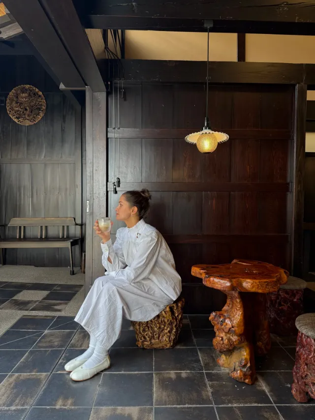 Annabel seated in a dark timber interior beneath a hanging lamp